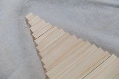 a piece of wood sitting on top of a cloth covered table next to a knife