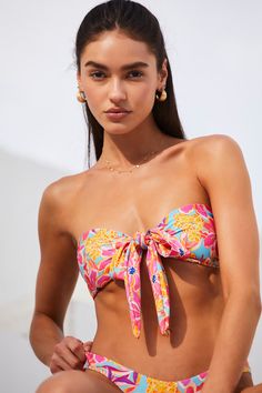 You'll always have enough room in your beach bag for a stunning look like the Lulus Vibrant Getaway Hot Pink Multi Floral Knot Bandeau Bikini Top! An abstract, multicolored floral print decorates stretchy tricot knit as it shapes this cute swim top that features a bandeau-inspired bodice with a trendy tie-front detail at the center and a sweetheart neckline. Removable padding. Fit: This garment fits true to size. Length: Size medium measures 6.25" from top to bottom. Bust: Works best for A to C Tropical Strapless Swimwear For Swimming, Tropical Strapless Swimwear, Strapless Tropical Print Swimwear, Tropical Strapless Swimwear For Beach, Multicolor Tie-side Swimwear For Vacation, Strapless Floral Print Swimwear For Sunbathing, Summer Strapless Swimwear For Beach Season, Strapless Floral Print Swimwear For Beach Party, Strapless Summer Swimwear For Beach Season