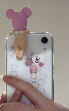 someone is holding up their phone case to take a photo with the doll on it