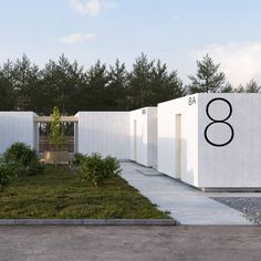 a white building with the number eight on it's side and trees in the background