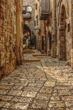 an alley way with stone buildings and cobblestones