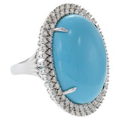 Elegance meets sparkling vitality in this 18kt white gold cocktail ring. A large, natural oval turquoise stone sits surrounded by 1.47 carats (total weight) of diamonds (F-G color, VS clarity). Size 6.75 US. Weight 14.1 gm. Oval Diamond Turquoise Ring For Formal Occasions, Formal Oval Turquoise Ring With Diamond, Oval Cocktail Ring, Oval Turquoise Ring With Diamond Accents, Cocktail Rings Diamond, Gold Cocktail Ring, Gold Cocktail, Diamond Cocktail Rings, Modern Ring