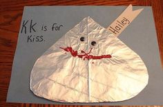 a piece of paper that has been made to look like a kite with the words k k is for kiss on it