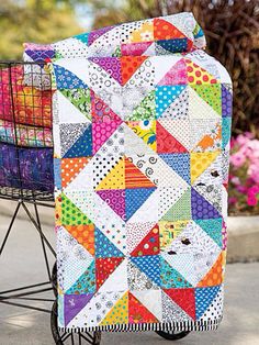 a colorful quilt sitting on top of a shopping cart