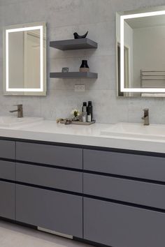 a bathroom with two sinks and mirrors on the wall