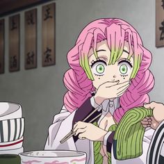 a woman with pink hair sitting at a table in front of a bowl and cup