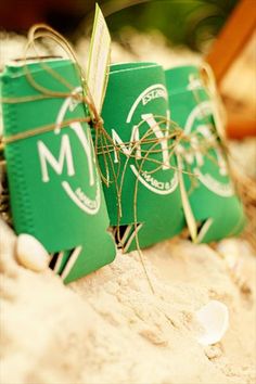 two green boxes tied up with twine on top of each other in the sand