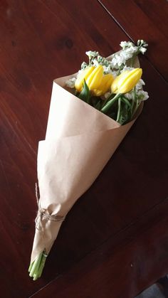 a bouquet of flowers wrapped in brown paper