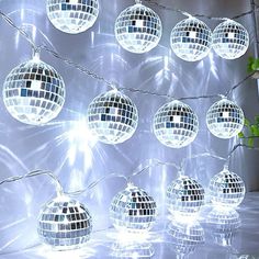 several disco ball lights hanging from a string