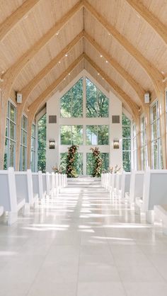 the inside of a church with rows of white chairs lined up in front of large windows