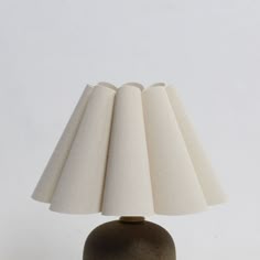 a table lamp that is on top of a wooden base with a white fabric shade