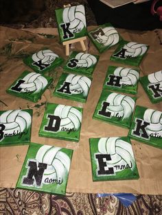 volleyball themed coasters laid out on top of a brown paper bag with the letters k and m painted on them