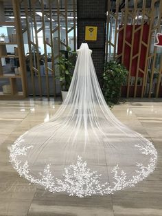 a white wedding veil on the floor in front of an entrance to a building with glass doors