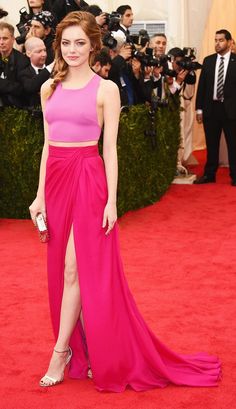 a woman in a pink dress standing on a red carpet