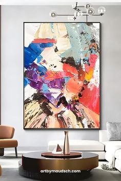 an abstract painting hangs on the wall in a modern living room