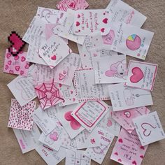 lots of valentine's day cards laid out on the floor for someone to write