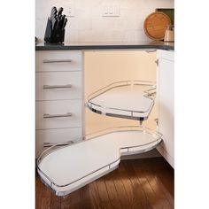 an open cabinet door in a kitchen with utensils