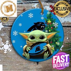 a christmas ornament with an image of baby yoda holding a star wars toy