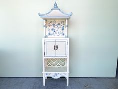 a blue and white cabinet sitting next to a wall