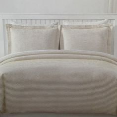 a white bed with two pillows on top of it