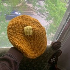 a person wearing a yellow crocheted hat with a bow