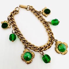 Vintage Peking Glass & Green Beaded Dangling Charm Bracelet. Etched gold plated metal chain with dangling gold tone Peking glass medallion and green glass beaded charms. In excellent vintage condition with minimal age appropriate wear. No chips no cracks. Measures 1 1/4 inches wide at widest point and is 7 1/4 inches long. Fold over clasp secure Green Chain Bracelet Jewelry, Green Metal Chain Jewelry, Green Metal Beaded Bracelets For Jewelry Making, Gold Bracelets With Dangling Beads For Gift, Green Metal Jewelry With Vintage Charm, Metal Beaded Dangle Charm Bracelet, Vintage Green Jewelry With Chain, Green Metal Charm Bracelet, Green Bohemian Jewelry With Vintage Charm