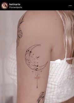 a woman with a tattoo on her arm is looking down at the moon and stars