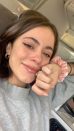 a woman sitting in the back seat of a car with her hands on her face