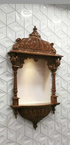 an ornate wooden shelf against a white tiled wall