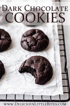 four chocolate cookies on a cooling rack with the words dark chocolate cookies