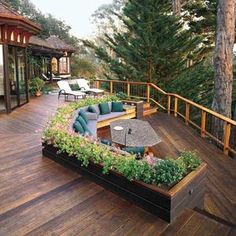 an outdoor deck with seating and trees in the background