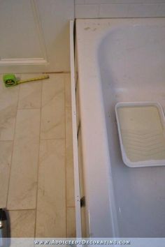 a bath tub sitting next to a white toilet in a bathroom under construction with tools on the floor