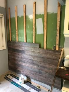 a room that has been painted green with some wood planks on the wall and floor