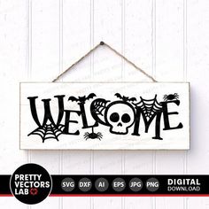 a sign that says welcome with a skull and spider webs on it, hanging from a