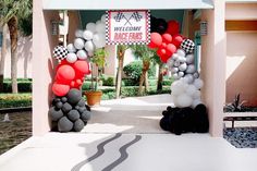 an entrance to a resort decorated with balloons