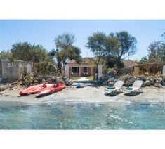 there are two boats parked on the beach next to each other in front of some houses