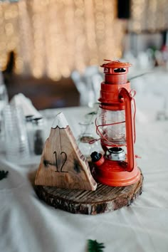 a red lantern sitting on top of a piece of wood next to a wooden slice