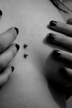 a black and white photo of a woman's stomach with nails on her belly