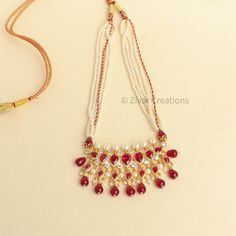 This unique Tanmani features 7 white-colored stones, complemented by pearls woven into the necklace strings. Red drop shape beads add a charming touch, enhancing the beauty of this exquisite design. Inspired by the Peshwa style, this necklace is a popular choice among women in Maharashtra. Crafted with 3mm pearls strings intricately woven and decorated with Jeri, the necklace comes with an adjustable thread. Please note that this is our handmade creation. You may also consider pairing it with ou Affordable Necklace For Puja And Diwali, Festival Pearl Drop Necklaces With Round Beads, White Temple Necklace With Pearl Drop For Festivals, White Ruby Bridal Necklace For Celebration, Traditional Adjustable White Kundan Necklace, Handmade White Pearl Necklace For Festive Occasions, Traditional Teardrop Bridal Necklace For Festive Occasions, White Pearl Temple Necklace, Traditional Handmade Pearl Beads