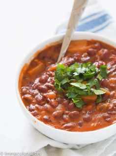 a white bowl filled with beans and cilantro