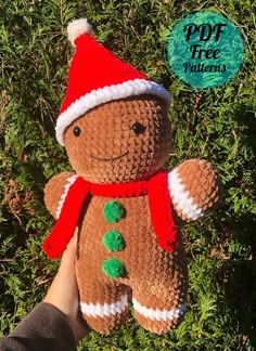 a hand holding a brown teddy bear wearing a santa hat