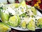 a white plate topped with broccoli covered in cheese next to other food items