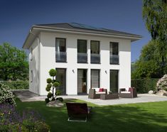 a white house with black shutters on the front and side windows, sitting in grass