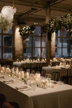 a long table is set with candles and flowers for an elegant dinner or function at the reception