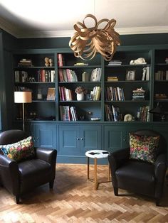 a living room with two chairs and a book shelf