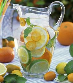 a pitcher filled with lemons and lime slices