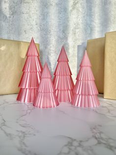 three pink christmas trees sitting on top of a table