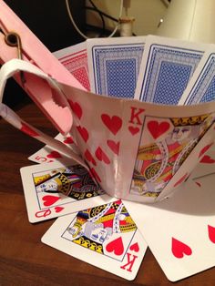 several playing cards are sitting on top of each other, with one folded up in the shape of a boat