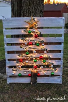 a christmas tree made out of pallet wood with lights and ornaments on the top