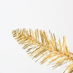 a gold christmas tree branch against a white background